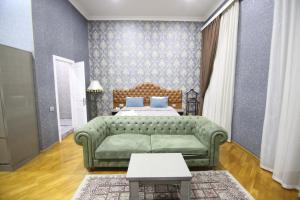 巴库Pilot Baku hotel的客厅配有绿色沙发和床。