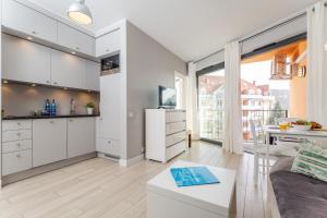 米兹多洛杰Horyzont Apartament z Klimatyzacją i Balkonem by Renters的厨房和带白色橱柜的客厅