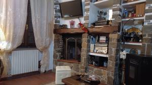 菲利内瓦尔达诺Casale Toscano in aperta campagna的客厅设有壁炉和电视。