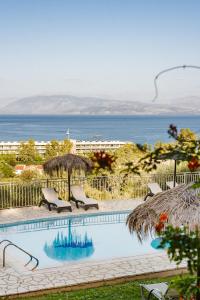达西亚Giorgos apartments的一个带椅子的游泳池,背景是大海