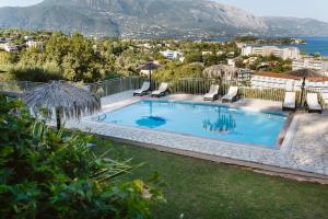 达西亚Giorgos apartments的一个带椅子的游泳池,享有海景