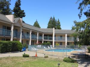 红木城红木城戴斯酒店的一座大建筑,在庭院里设有一个游泳池