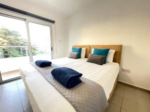 阿依纳帕Aurora Holiday Apartment - Ayia Napa的一间卧室配有两张带蓝色枕头的床。