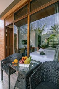 富国Valentina Resort & Spa Phu Quoc的玻璃桌,上面放一碗水果