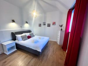 约尔Happy Sandy Feet - Modern, Cozy & Warm Holiday Home with Lovely Sea Views in Youghal`s Heart - Top-Notch Electric Heaters - Long Term Price Cuts的一间小卧室,配有一张床和一个红色的门