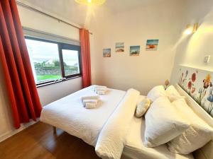 约尔Happy Sandy Feet - Modern, Cozy & Warm Holiday Home with Lovely Sea Views in Youghal`s Heart - Top-Notch Electric Heaters - Long Term Price Cuts的一间卧室配有带毛巾的床