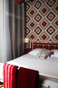 VicdessosEau Berges的一张带红色毯子的床和一堵墙
