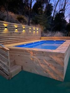 圣何塞德迈波Cabañas del Maipo的一个带木制甲板和游泳池的游泳池