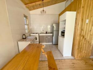 圣何塞德迈波Cabañas del Maipo的厨房配有白色冰箱和木桌