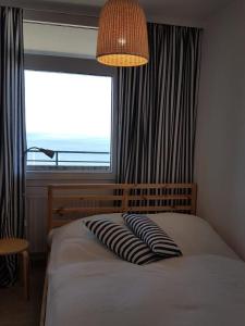 达默Strandhotel Wohnung 62的一间卧室设有一张大床和大窗户