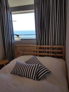 达默Strandhotel Wohnung 62的窗户前的一张带两个枕头的床