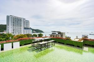 头顿Sunset Sea Bãi Dâu Hotel Vũng Tàu的建筑物屋顶上的桌椅