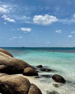 亭可马里Anoo Beach Villa的晴天,海滩上拥有岩石和海洋