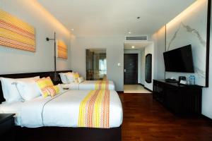 万象Mintra Hotel的酒店客房设有两张床和一台平面电视。