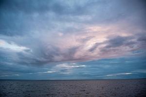 亚斯塔尔尼亚Maszoperia Sun4hel Kite & Wind & Surf的一片阴云密布的天空,在一大片水体上