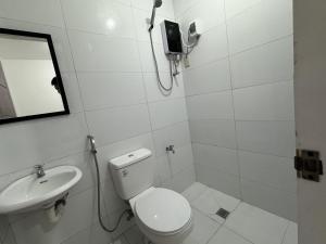 黎牙实比RedDoorz near Mariners Legazpi的白色的浴室设有卫生间和水槽。