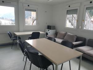 弗拉塔赫Gletscher-Trail Hostel的客厅配有桌椅和沙发