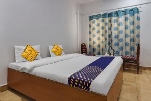 海得拉巴SPOT ON Apsara Hotel的一间卧室配有蓝色和黄色枕头的床