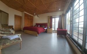 布尔班Haven Lodge Bhurban, 6BR Holiday Home in Hill Station的一间卧室设有红色的床,还有一些窗户