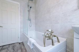 约克Cosy Three-Bedroom House Near City Centre with Free Parking的白色的浴室设有浴缸和水槽。