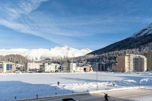圣莫里茨Idyllic apartment in St. Moritz的一座白雪覆盖的城市,以群山为背景