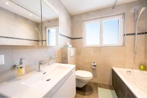 圣莫里茨Idyllic apartment in St. Moritz的浴室配有盥洗盆、卫生间和浴缸。