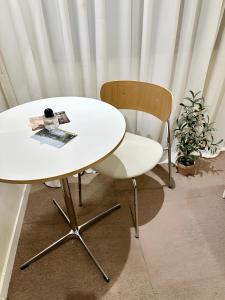 首尔SSH Ikseon peter cat Hostel的客房内的一张白色桌子和一把椅子