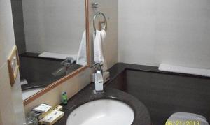 浦那FabHotel Prime Orchard Hospitality的一间带水槽和镜子的浴室