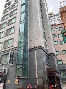 首尔SSH Ikseon peter cat Hostel的城市街道上一座高大的建筑,设有玻璃窗