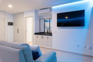 圣地亚哥港OBSIDIAN Mirador del Oceano的客厅配有蓝色的沙发和电视