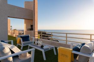 圣地亚哥港OBSIDIAN Mirador del Oceano的一个带桌椅的海景阳台
