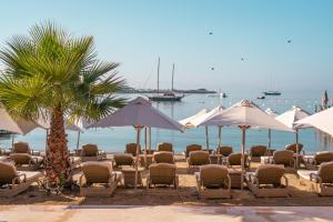 居姆贝特InOne Mucho Selection Hotel的沙滩上的一把椅子和遮阳伞