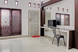 班达楠榜OYO 92945 Guest House Nusa Indah Syariah的客房设有一张桌子、一台电脑和一把椅子