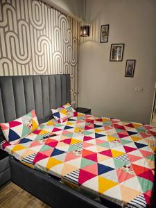 大诺伊达Luxury Rooms near expomart的卧室里一张床上有五颜六色的被子
