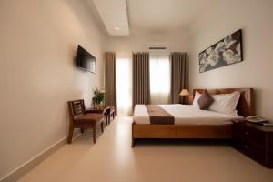 胡志明市Ngọc Châu Hotel的卧室配有床、椅子和窗户。