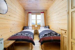 玛丽亚阿尔姆Ski-in & Ski-out out Chalet Maria with amazing mountain view的小木屋内的两张床,设有窗户