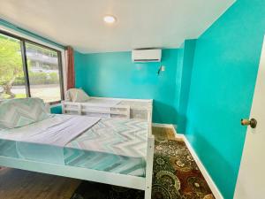 科罗尔Ngermid Oasis Cozy 2 BD 1BA Home, Scenic View, Secluded, Beautiful Location的小房间设有床和蓝色的墙壁