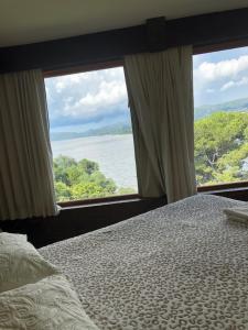 维拉卡洛斯帕兹casas lago san roque的一间卧室配有一张床,享有水景