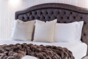 维罗纳PALAZZO RISTORI的一张带白色枕头和棕色毯子的床
