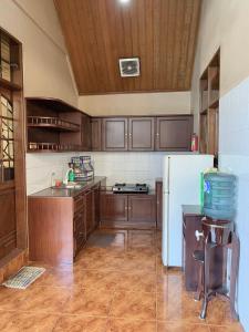 伦邦努安萨阿拉姆别墅的厨房配有木制橱柜和白色冰箱。