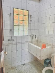 伦邦努安萨阿拉姆别墅的带浴缸的浴室和窗户。