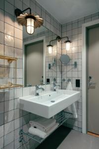 哥德堡Liseberg Grand Curiosa Hotel的浴室设有白色水槽和镜子