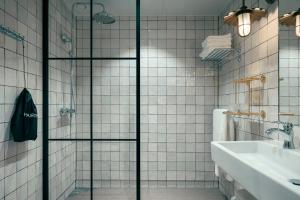 哥德堡Liseberg Grand Curiosa Hotel的一个带水槽的浴室内的玻璃淋浴间门