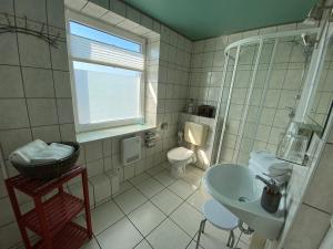 雷希林Aparthotel " Zur Müritz"的白色的浴室设有水槽和卫生间。