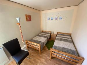 雷希林Aparthotel " Zur Müritz"的一间设有两张床和椅子的房间
