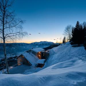 莱维科特尔梅nif: alpine taste的雪覆盖的房子,灯照在里面
