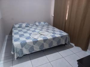 伊塔蒂巴Pousada Doce Lar的一张带蓝色和白色棉被的床