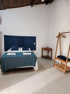 伊利亚贝拉La Bella Suítes的一间卧室配有蓝色的床和椅子