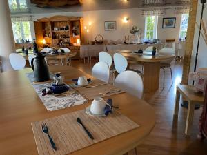 雷希林Aparthotel " Zur Müritz"的用餐室配有木桌和白色椅子