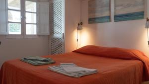 孔波尔塔Cabana da Comporta的橙色的床,上面有两条毛巾